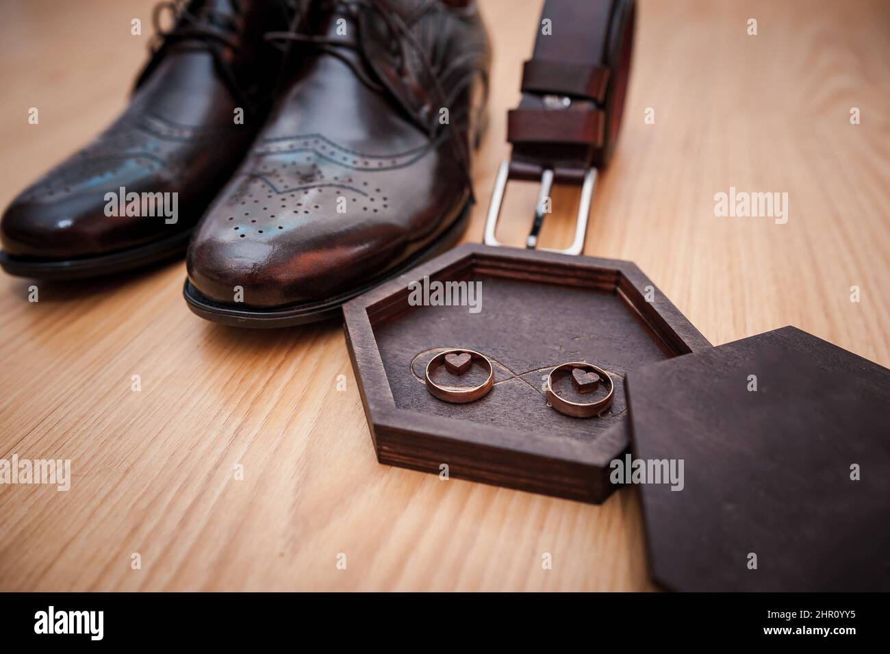Chaussures en cuir pour hommes, une paire d'anneaux de mariage en or dans une boîte en bois. Accessoires pour marié Banque D'Images