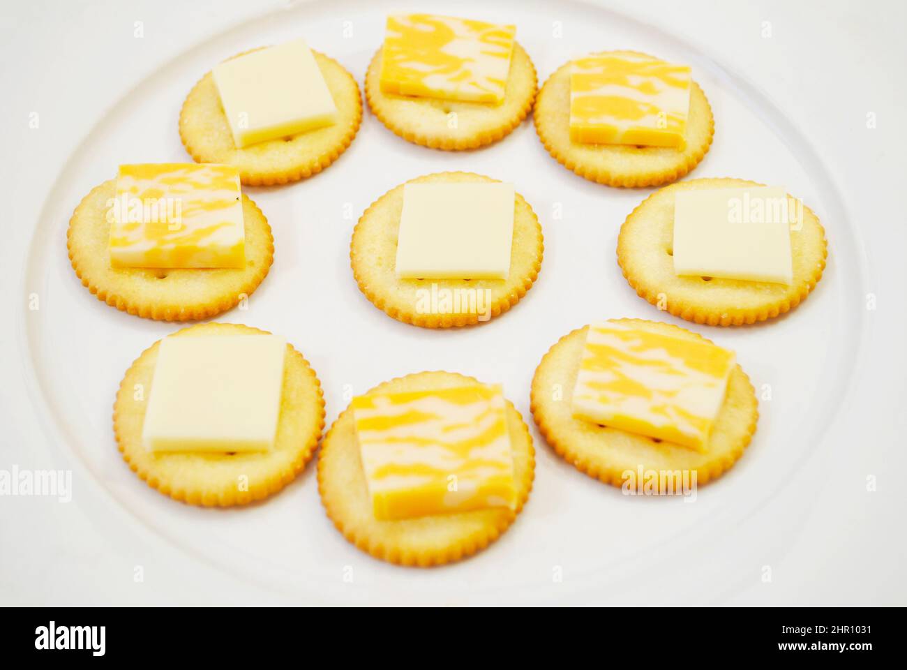 Biscuits salés ronds avec fromage en tranches sur le dessus Banque D'Images