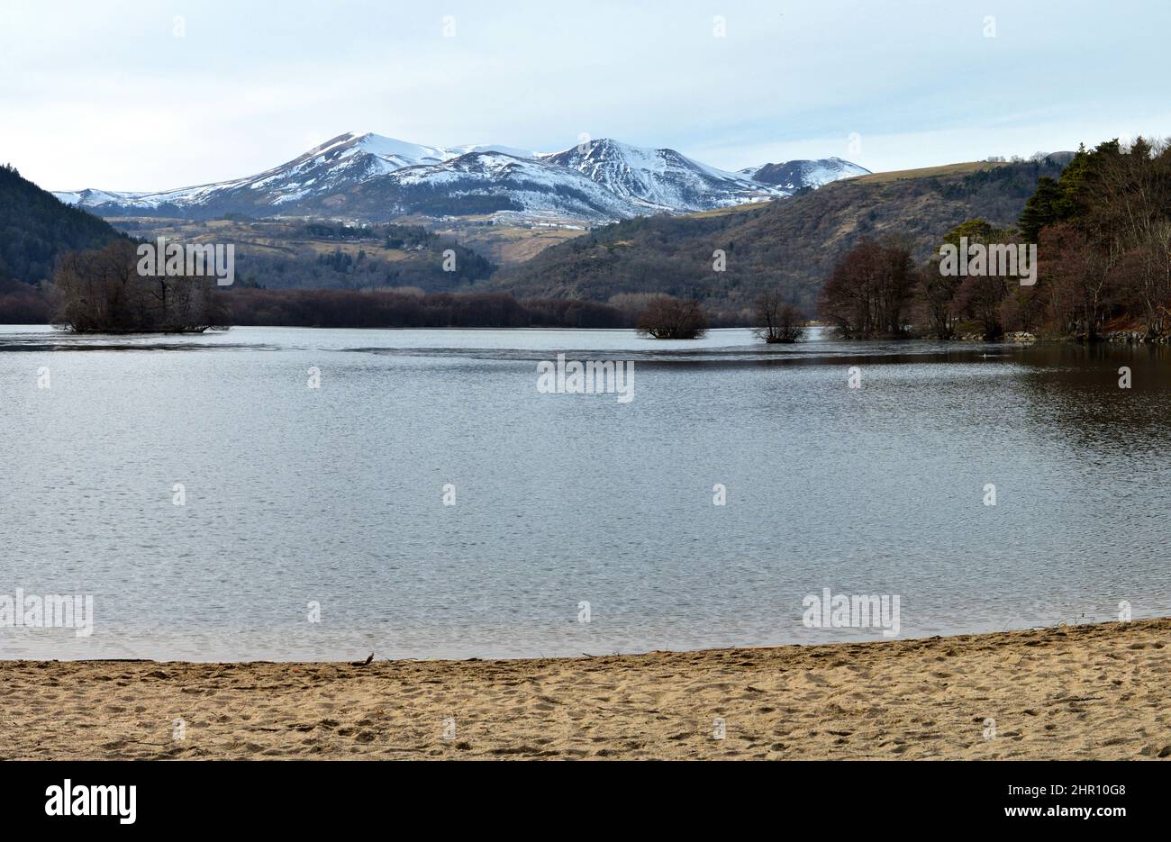 Une plage au-dessus d'un lac de montagne en face d'une montagne volcanique en Auvergne Banque D'Images