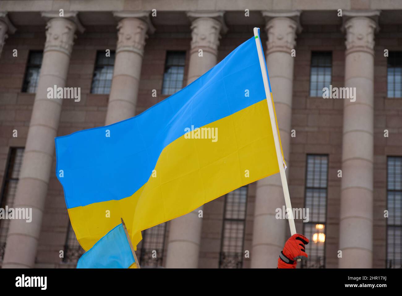 Helsinki, Finlande - 22 février 2022 : manifestant dans un rassemblement contre l'agression militaire russe et l'occupation de l'Ukraine portant le drapeau ukrainien Banque D'Images