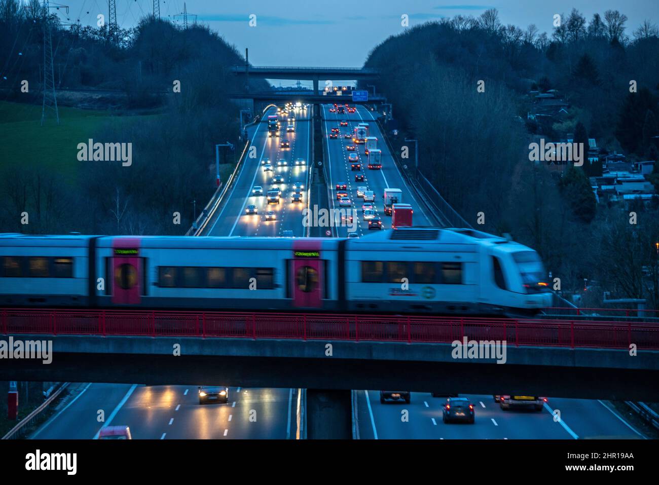 L'autoroute A3, circulation en soirée sur 6 voies, train local S-Bahn, Regiobahn, S28, en traversant l'autoroute, Sur le chemin entre Kaarst et Wupper Banque D'Images