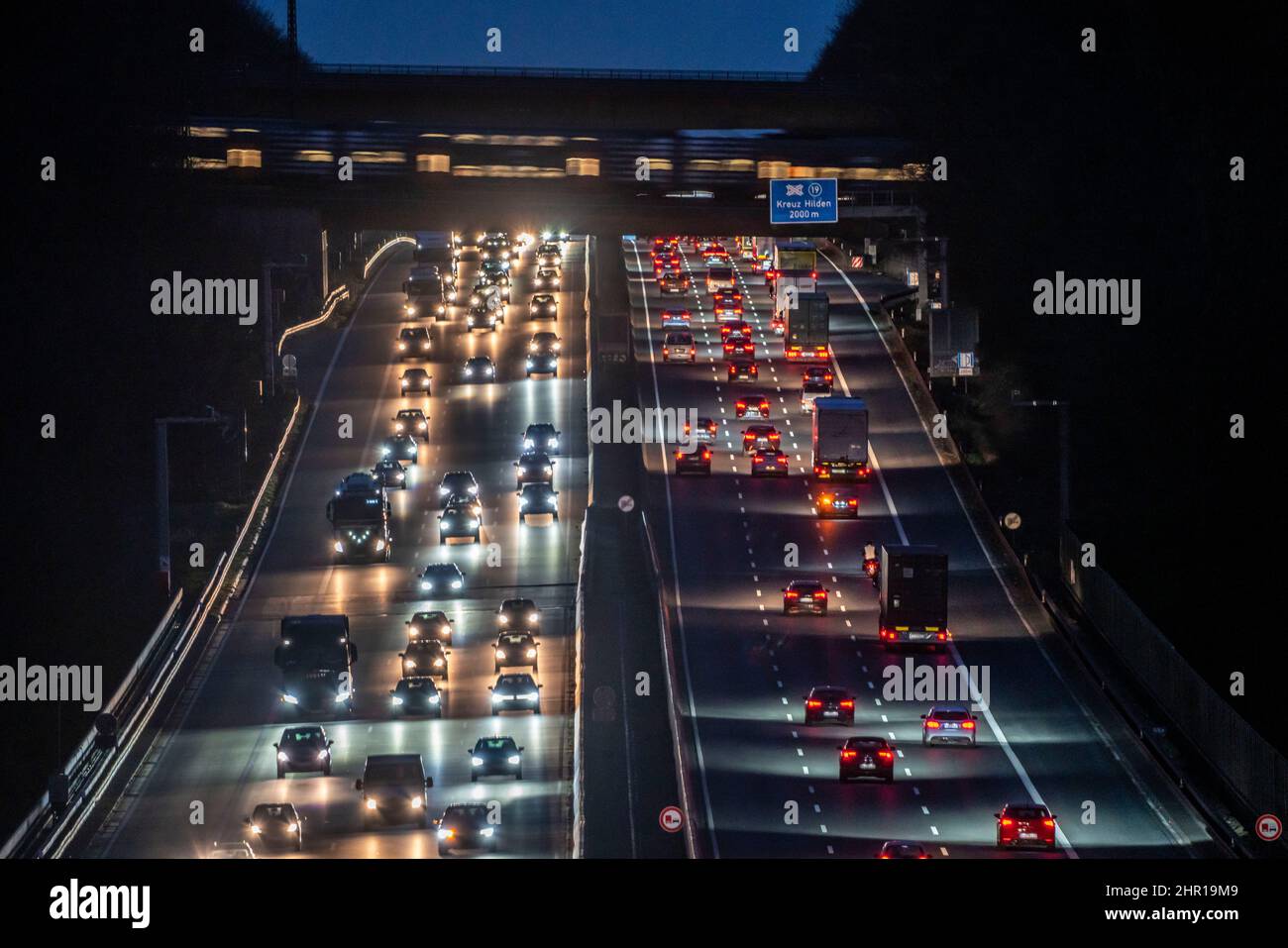 L'autoroute A3, circulation en soirée sur 6 voies, train de banlieue RRX, traversée de l'autoroute, en direction de Düsseldorf, avant le Hilden mot Banque D'Images