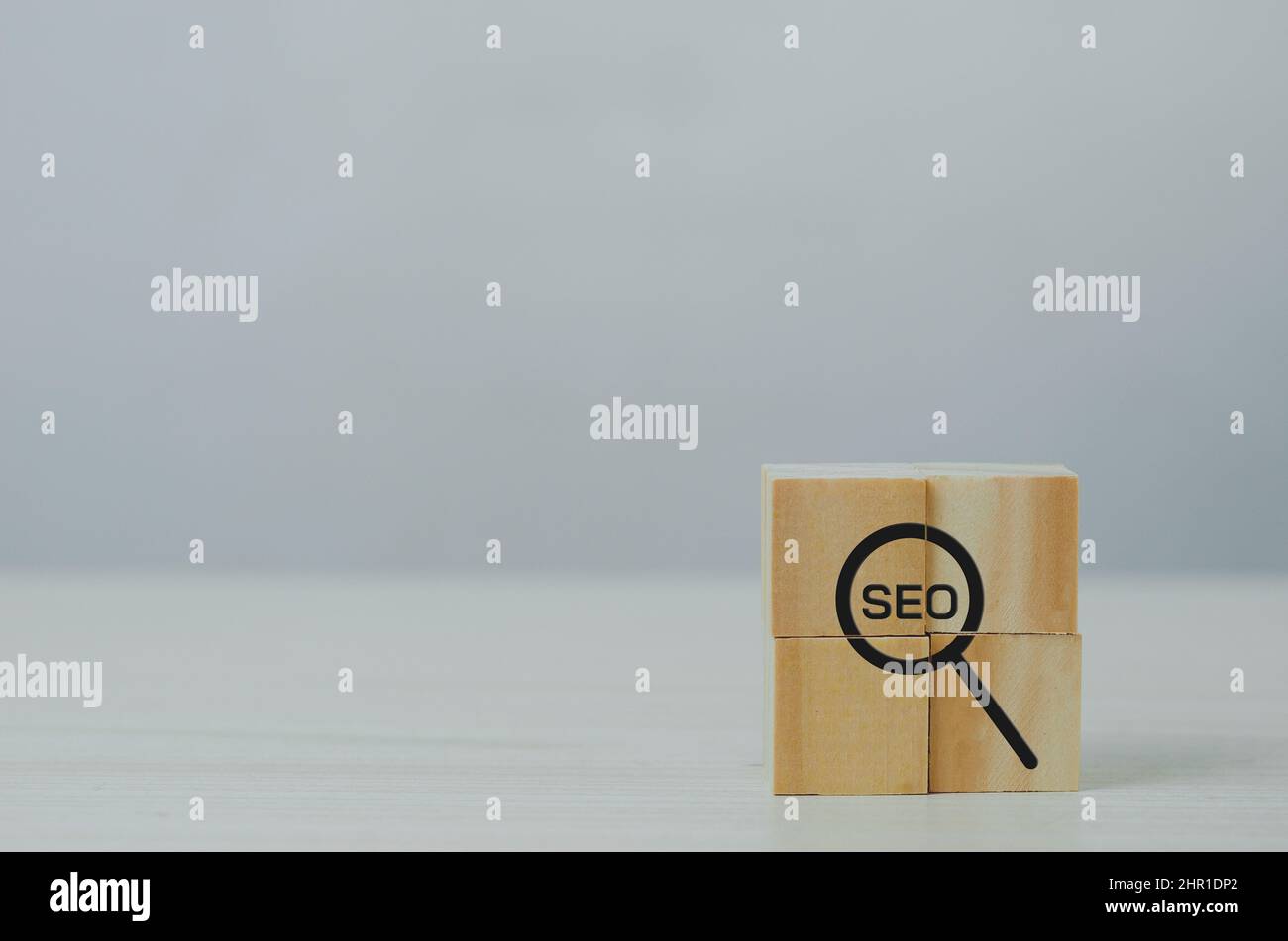 Cube en bois avec icône de loupe et de l'acronyme de « Digital Marketing Strategy SEO Search Engine Optimization Ranking concepts ». Banque D'Images