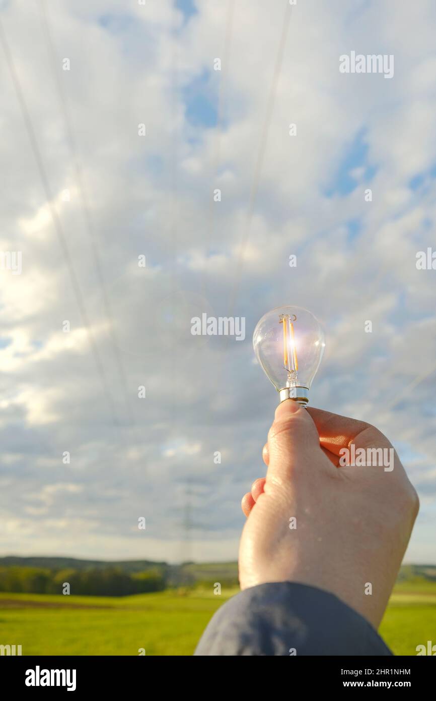 Électricité et énergie verte.ampoule en main .sources d'énergie naturelles alternatives Banque D'Images