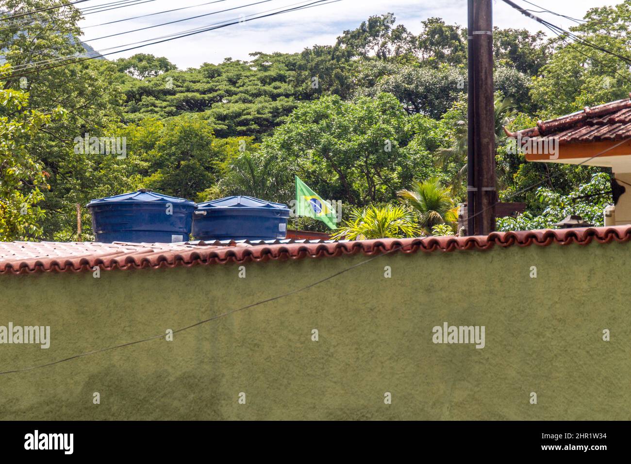 Drapeau brésilien volant dans l'arrière-cour d'une maison à Rio de Janeiro, Brésil. Banque D'Images