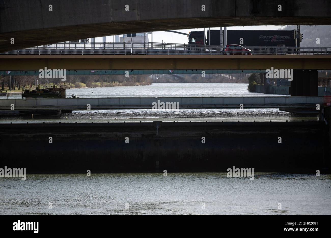 Stuttgart, Allemagne. 17th févr. 2022. Un camion traverse un pont, en dessous de lui le Neckar et le déversoir du barrage de Cannstatt peut être vu. L'eau se porte bien, les poissons moins. Par-dessus tout, l'expansion de la navigation sur le Neckar a entraîné une diminution importante des stocks de poissons locaux. (À dpa 'Neckar - de l'eau sauvage à une chaîne de lacs avec de moins en moins d'espèces indigènes de poissons") Credit: Marijan Murat/dpa/Alay Live News Banque D'Images