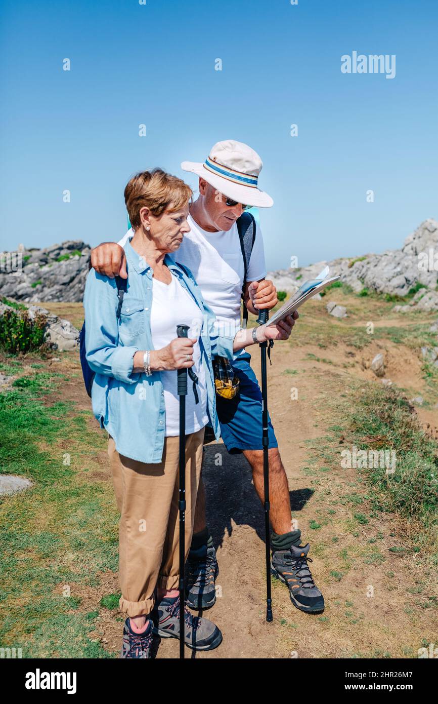 Couple senior randonnée regardant la carte dans le paysage rocheux Banque D'Images