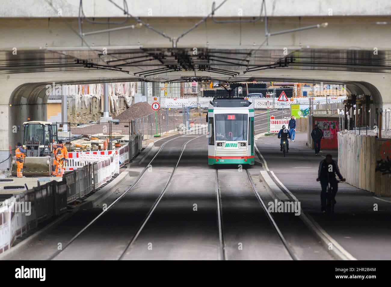 Magdebourg, Allemagne. 24th févr. 2022. Des cyclistes et un tramway traversent une partie déjà libérée du chantier de construction du tunnel de la ville. Les travaux de construction ont débuté en 2015 et sont en cours sur la surface de la route dans les tunnels routiers. Le projet de construction devrait être achevé et remis en mains en décembre 2022. Credit: Klaus-Dietmar Gabbert/dpa-Zentralbild/ZB/dpa/Alay Live News Banque D'Images