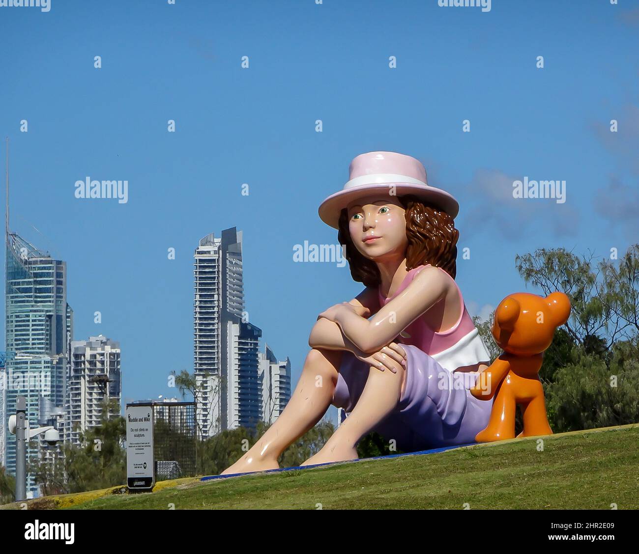 Sculpture publique « addie and Mike » dans les parcs de la Gold Coast, en Australie. Grande fille et ours en peluche sur une colline herbeuse, face à la mer. Banque D'Images