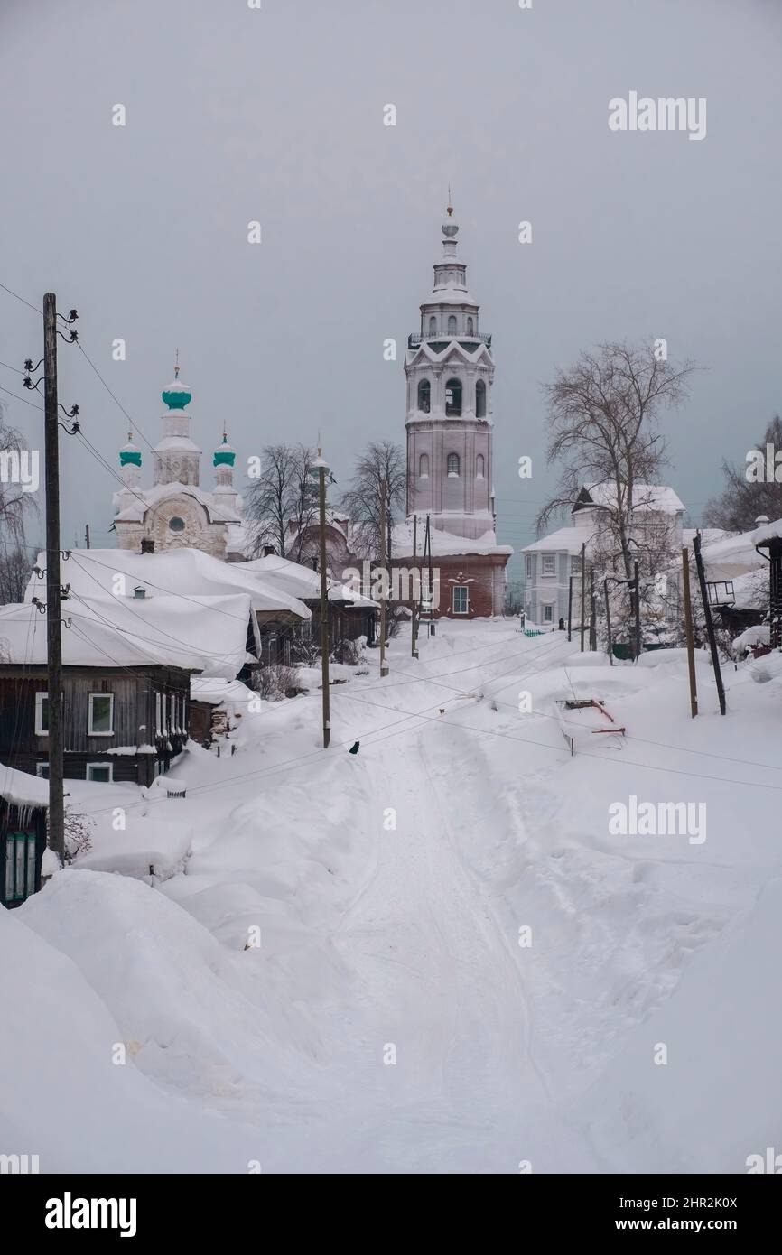 Rue enneigée dans l'ancienne ville de Cherdyn. maisons en bois et églises orthodoxes en hiver. Perm région Russie. Banque D'Images