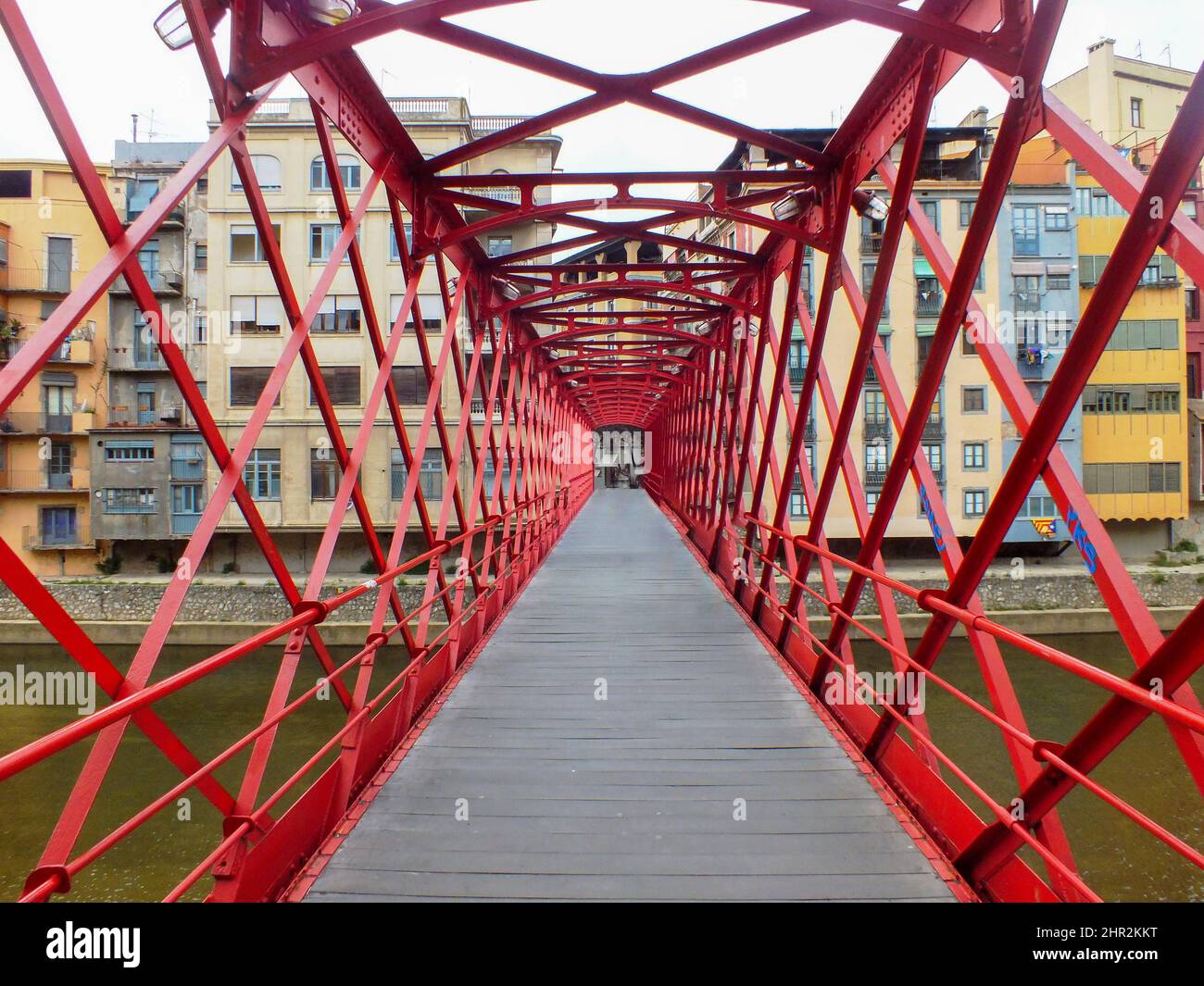 Gérone, Catalogne, Espagne - 31 décembre 2012 : Pont en fer rouge d'Eiffel en face de l'Onyar et maisons jaunes colorées, anciens étals de poissons, quartier juif Banque D'Images