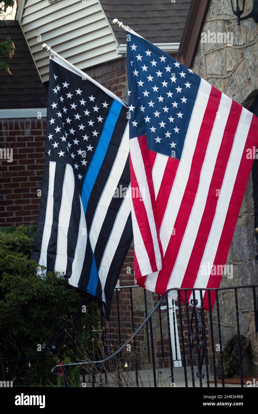 Une maison avec un drapeau américain standard et un drapeau américain mince de ligne bleue symbolisant le soutien de la police. Banque D'Images