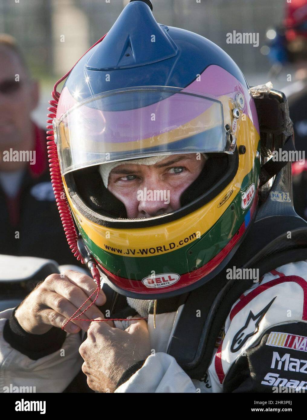 Jacques Villeneuve, pilote de Penske Racing, s'attache sur son casque avant  de se rendre à la séance de qualification pour la course nationale NASCAR  Napa Auto Parts 200 le vendredi 19 août