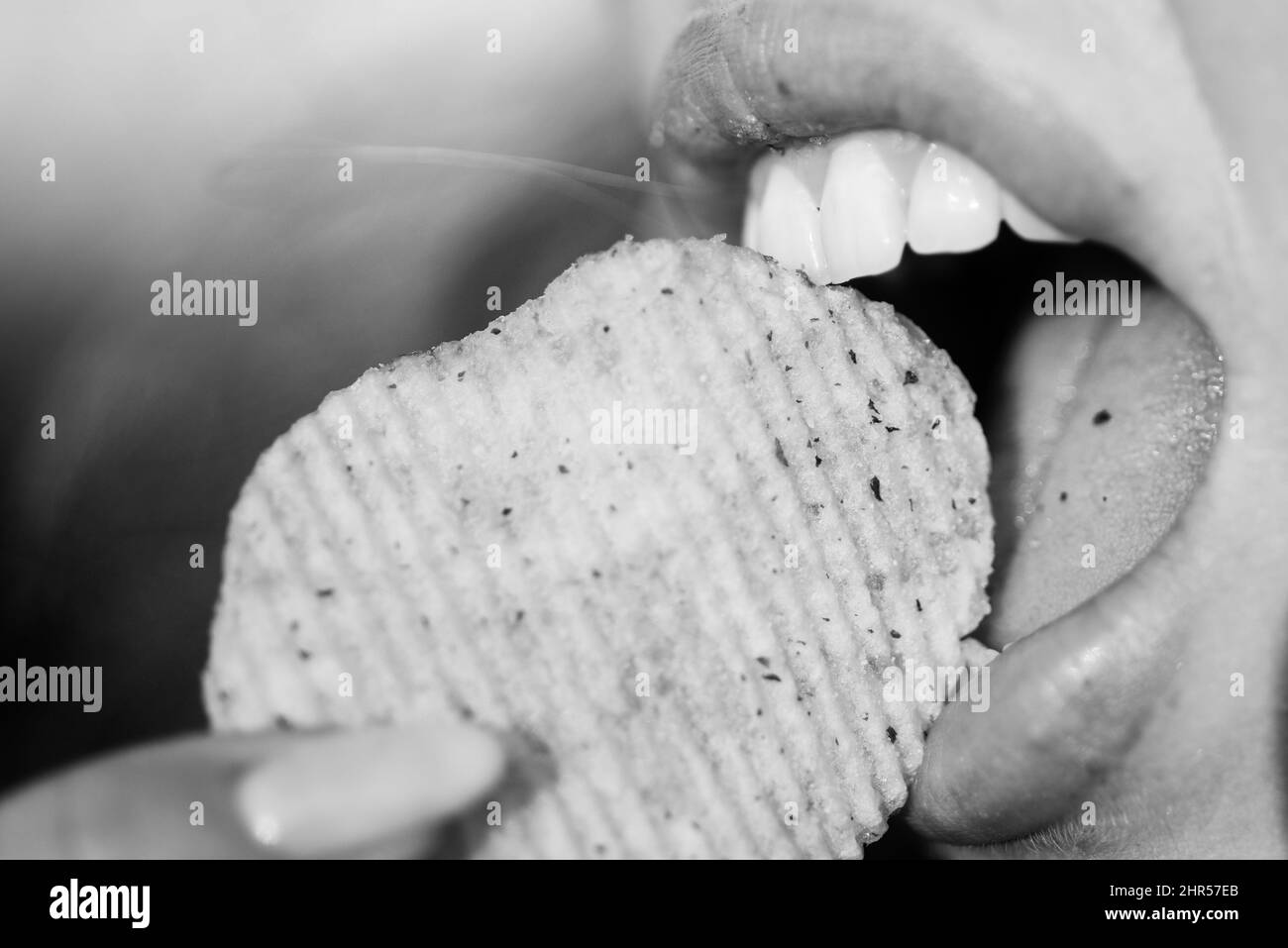 Soins dentaires. Fermer la bouche de fille avec plaisir mange des chips de pomme de terre. Banque D'Images