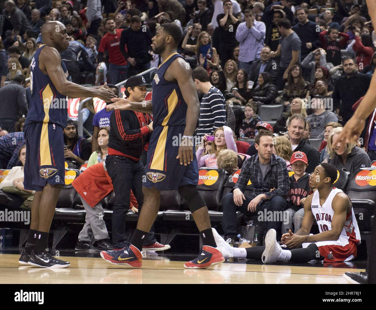 Les Raptors de Toronto DEMAR DeRozan sont assis sur le plancher tandis que les Pelicans de la Nouvelle-Orléans Quincy Pondexter (à gauche) et Tireke Evans se félicitent mutuellement pour leur victoire dans l'action de la NBA à Toronto le dimanche 18 janvier 2015. LA PRESSE CANADIENNE/Frank Gunn Banque D'Images