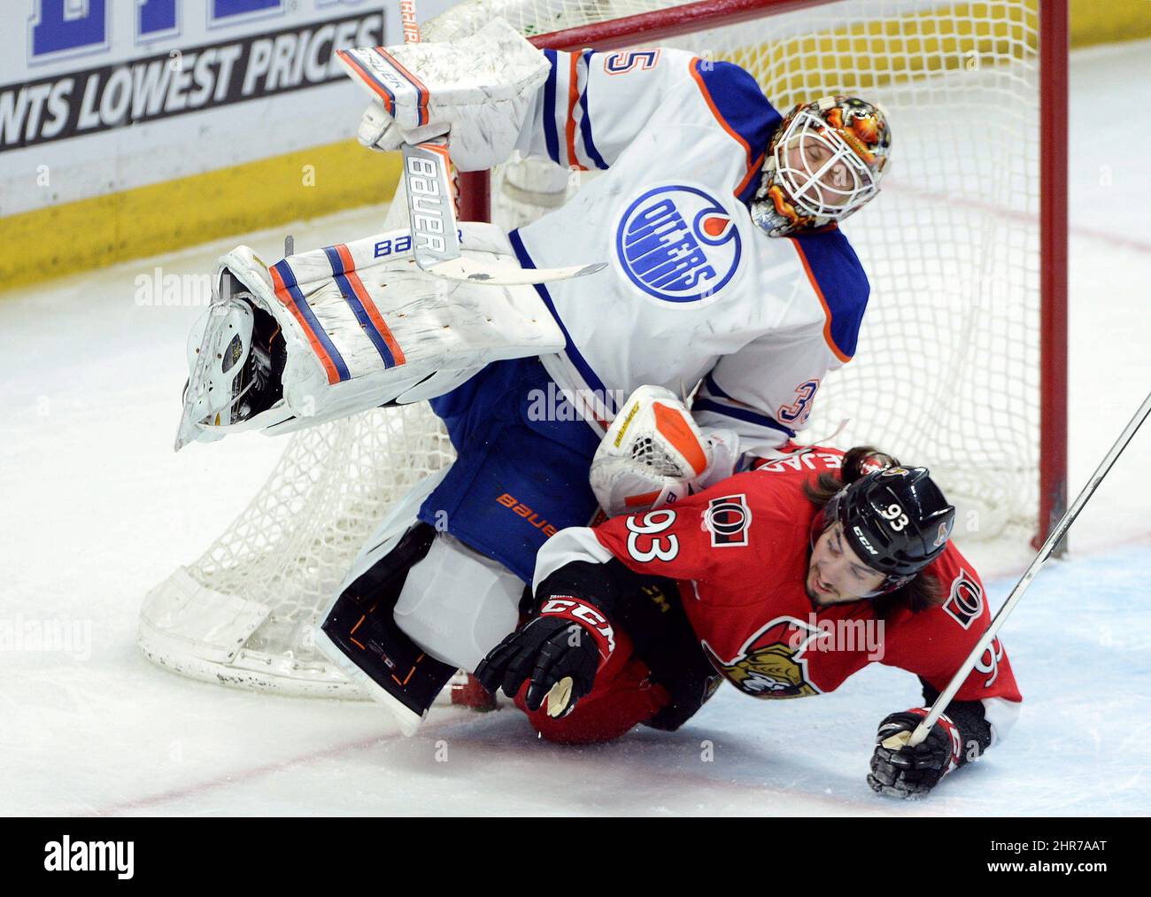 Mika Zibanejad, de droite, de sénateurs d'Ottawa, se lance dans le gardien de but des Oilers d'Edmonton, Viktor Fasth, lors de la première période d'action de hockey de la LNH à Ottawa, le samedi 14 février 2015. LA PRESSE CANADIENNE/Sean Kilpatrick Banque D'Images
