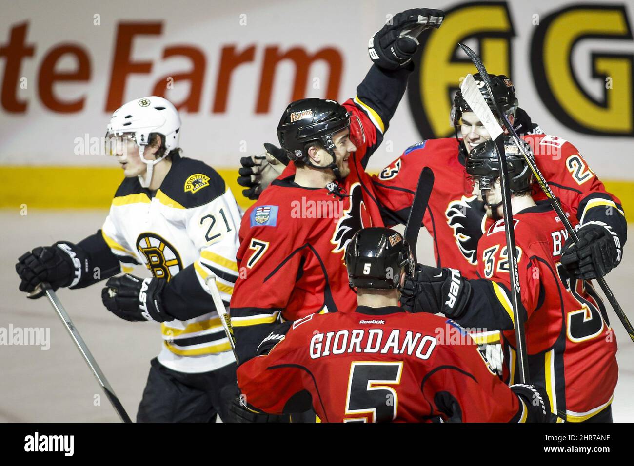 Boston Bruins Loui Eriksson, à gauche, de Suède, s'éloigne en voiture tandis que Calgary Flames TJ Brodie, au centre à gauche, célèbre son but gagnant avec ses coéquipiers pendant les heures supplémentaires de hockey de la LNH à Calgary, le lundi 16 février 2015.THE CANADIAN PRESS/Jeff McIntosh Banque D'Images