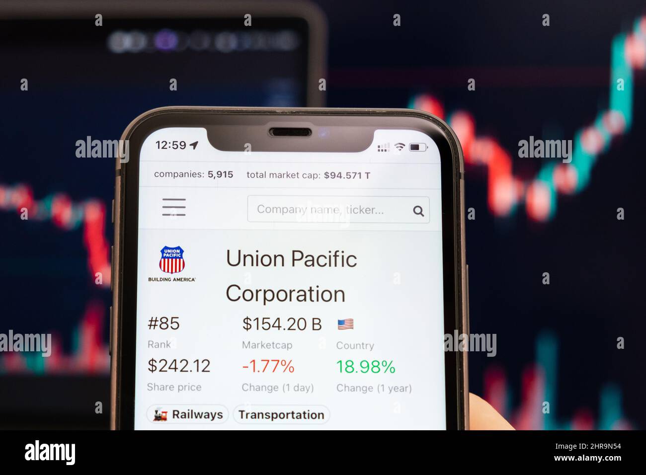 Union Pacific Corporation cours de l'action sur l'écran de téléphone cellulaire dans les mains de l'évolution de la bourse avec échange de chandelier analyse graphique, février 2022, San Francisco, USA Banque D'Images