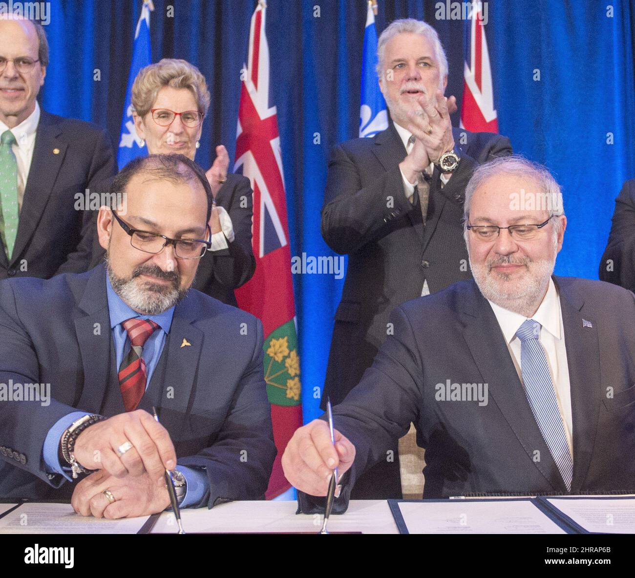 Glenn Thibeault, avant gauche, ministre de l'énergie de l'Ontario, et Pierre Arcand, avant droit, ministre de l'énergie et des Ressources naturelles du Québec signent une entente sur l'énergie sous les noms de Kathleen Wynne, première ministre de l'Ontario, et Philippe Couillard look, premier ministre du Québec, à Montréal, le jeudi 15 décembre 2016. LA PRESSE CANADIENNE/Ryan Remiorz Banque D'Images