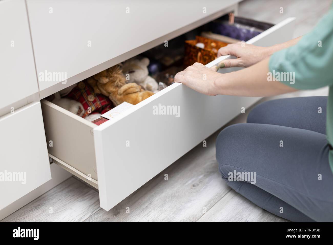 femme assise devant un tiroir à fond ouvert d'une commode. Photo de haute qualité Banque D'Images