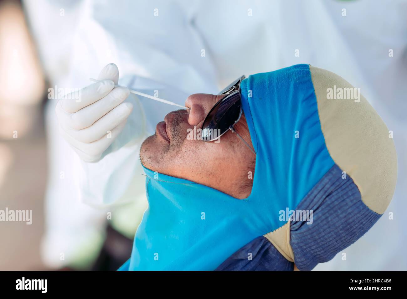 Homme ayant un test d'antigène COVID-19 effectué par un professionnel de la santé Banque D'Images