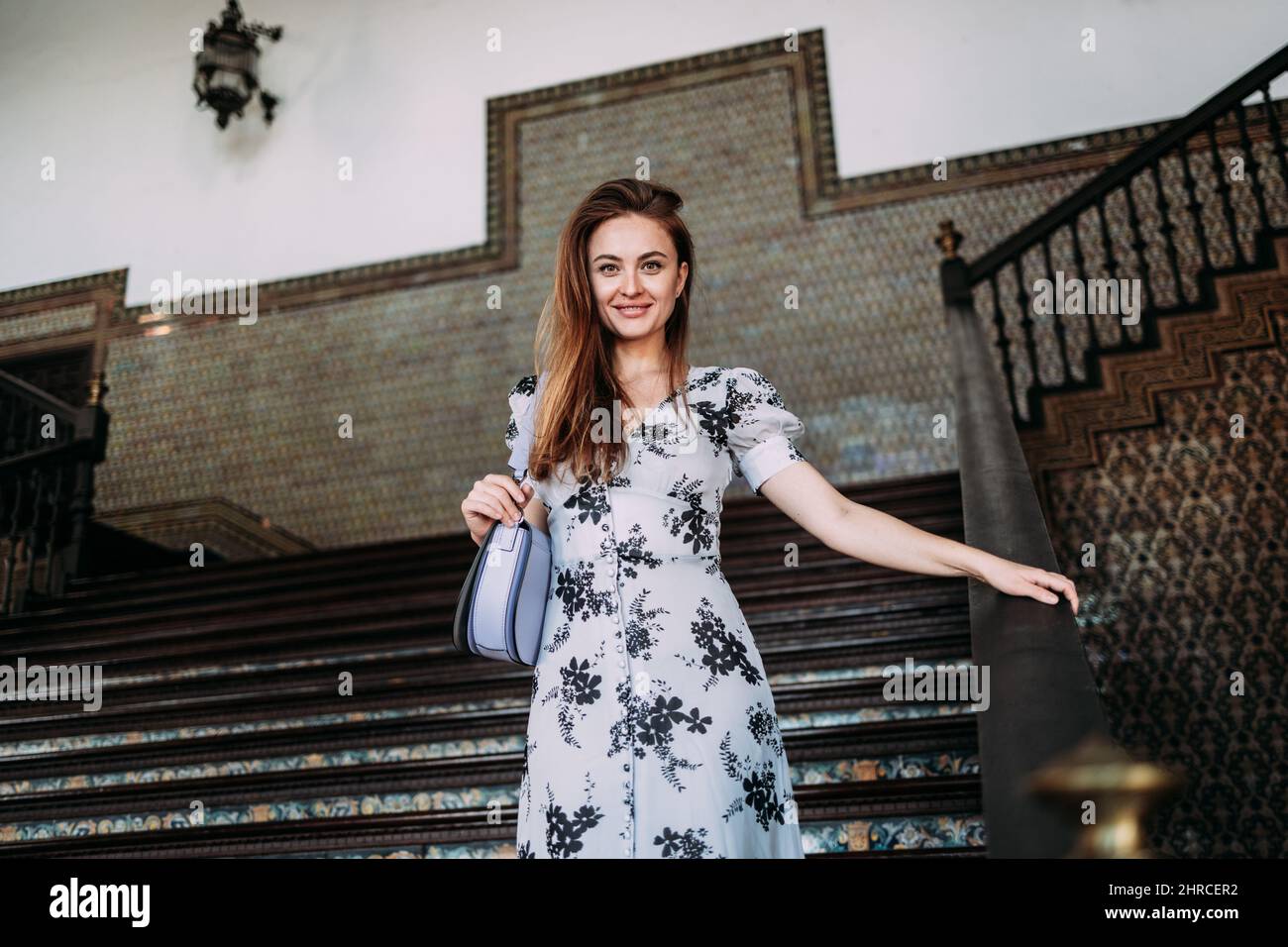 Belle femme insouciante descendant quelques escaliers d'un château touristique en Europe Banque D'Images