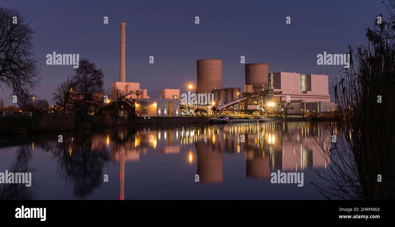 coup de feu de nuit coloré d'une centrale au charbon. Au premier plan le canal de livraison du charbon Banque D'Images