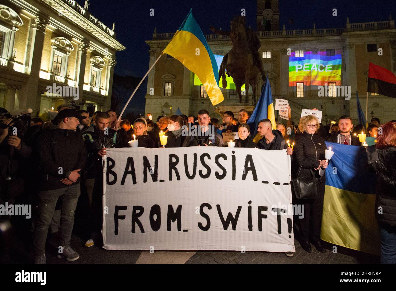 Rome, Italie. 25th févr. 2022. Le peuple ukrainien montrant la bannière « Ban Russia from Swift » avant la marche aux chandelles organisée par le maire de Rome, Roberto Gualtieri, en solidarité avec le peuple ukrainien et pour appeler à la paix immédiate en Ukraine. La guerre contre l'Ukraine - et l'invasion russe qui en a résulté - a été déclarée tôt le matin du 24th février par le Président de la Fédération de Russie, Vladimir Poutine. Crédit : LSF photo/Alamy Live News Banque D'Images