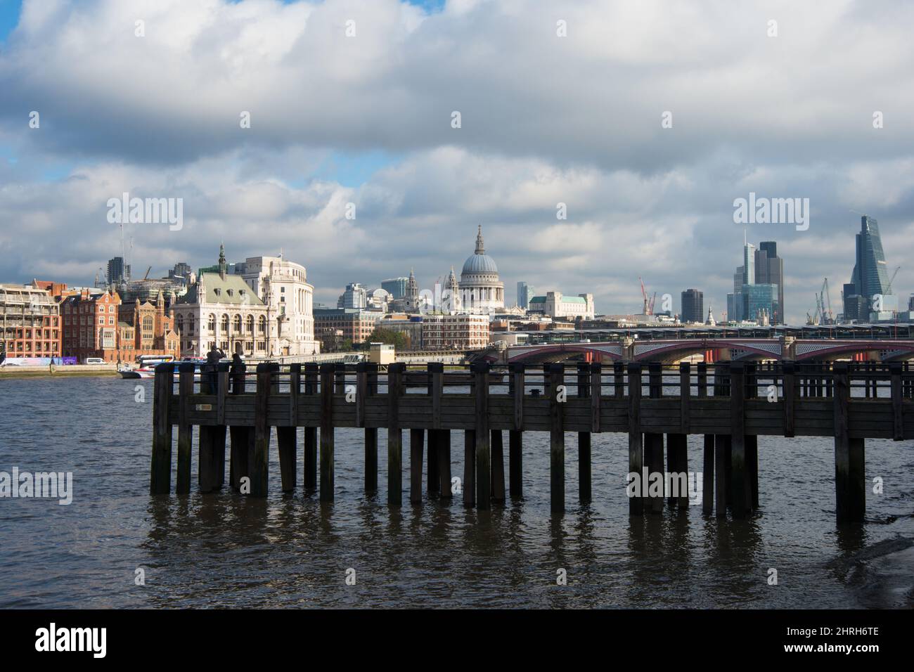 Vue magnifique sur les gratte-ciel de Londres depuis Riverbank. Ancienne jetée en bois, cathédrale Saint-Paul et gratte-ciel. Jour nuageux, coucher de soleil. Banque D'Images