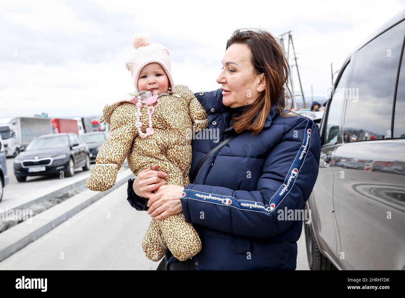 La famille ukrainienne marche dans une rue très fréquentée à côté du poste frontalier alors que des dizaines de milliers de personnes s'échappant d'Ukraine entrent en Pologne après que la Russie ait pris plus de territoire ukrainien - poste frontière entre la Pologne et l'Ukraine à Medyka, en Pologne, le 25 février 2022. Alors que l'armée de la Fédération de Russie a franchi les frontières ukrainiennes, le conflit entre l'Ukraine et le russe devrait forcer jusqu'à 5 millions d'Ukrainiens à fuir. La plupart des réfugiés vont chercher asile en Pologne. La plupart des évadés actuels sont des familles de ces Ukrainiens qui travaillent déjà en Pologne. Les postes frontière sont remplis de milliers d'hommes et de femmes qui attendent leur lo Banque D'Images