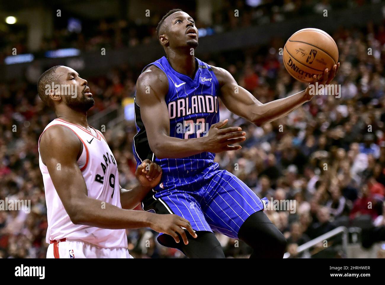 Centre des rapaces de Toronto Serge Ibaka (9) regarde le gardien magique d'Orlando Jerian Grant (22) se rendre sur le net pendant la deuxième moitié de l'action de basketball de la NBA à Toronto le dimanche 24 février 2019. LA PRESSE CANADIENNE/Frank Gunn Banque D'Images