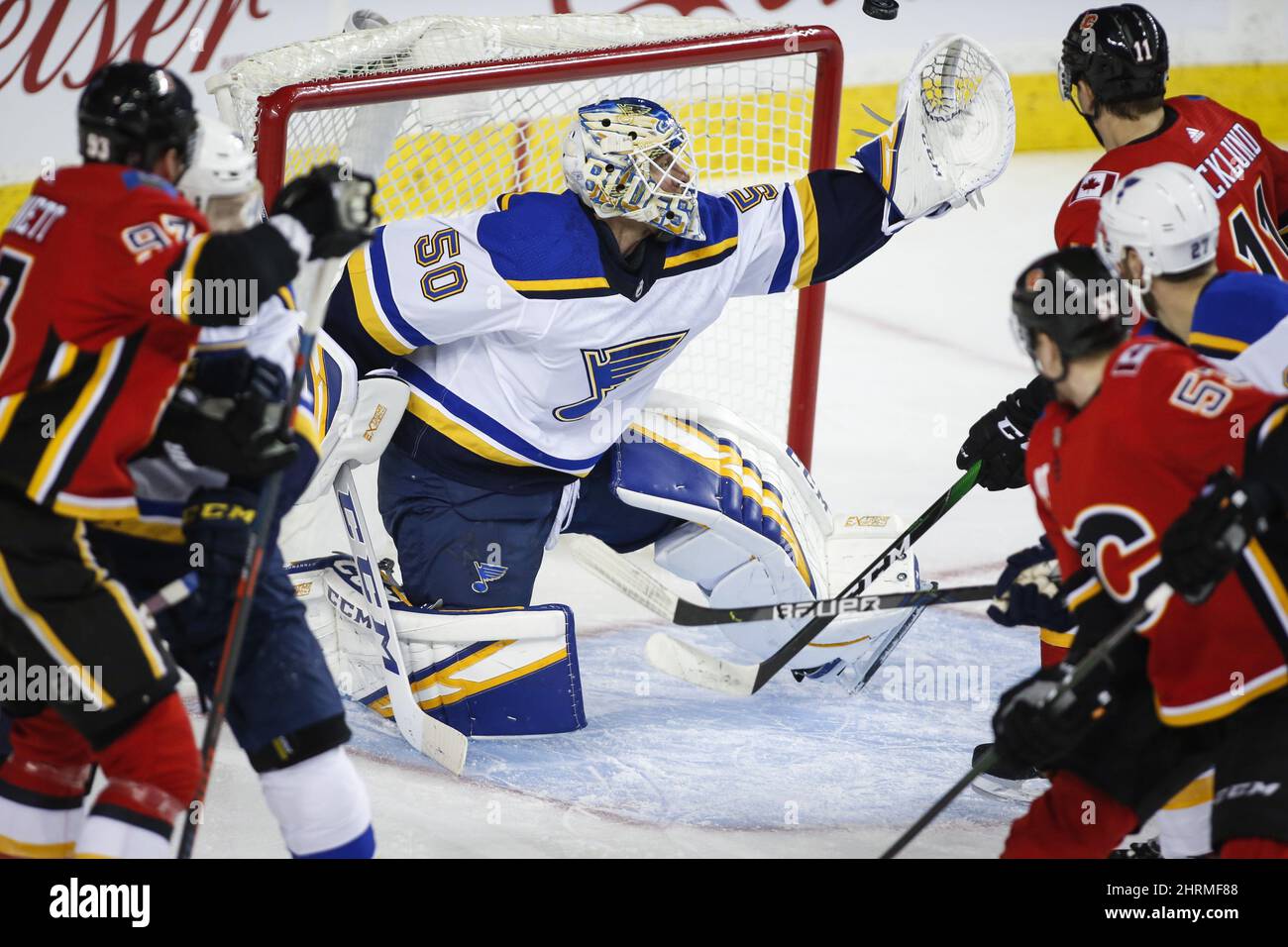 Le gardien de but de St. Louis Blues Jordan Binnington, au centre, s'empare du palet tandis que les flammes de Calgary regardent pendant la première période de l'action de hockey de la LNH à Calgary, le mardi 28 janvier 2020. LA PRESSE CANADIENNE Jeff McIntosh Banque D'Images