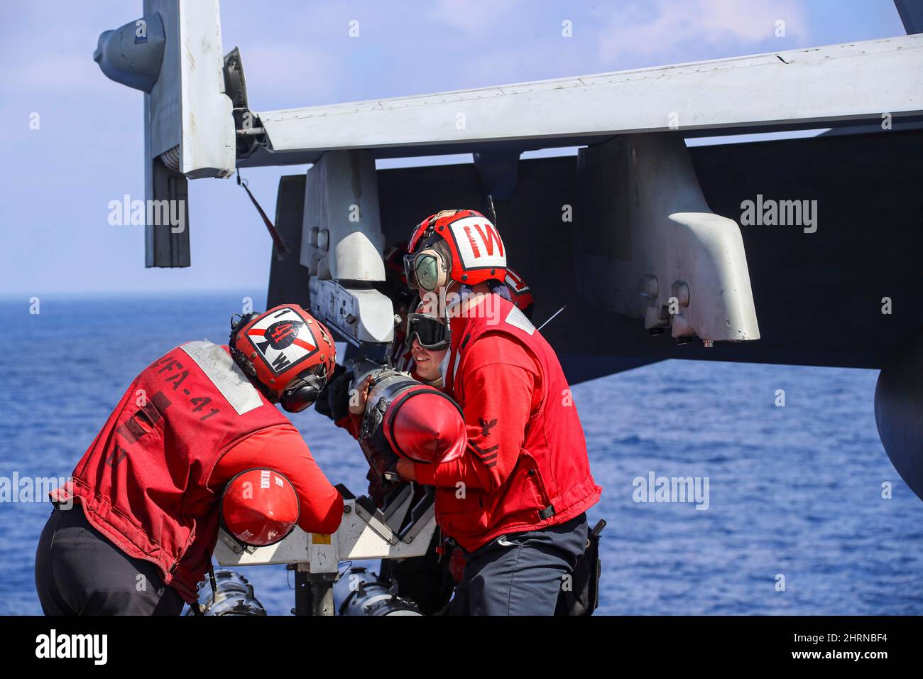 MER DES PHILIPPINES (fév 24, 2022) les marins, affectés aux « Black Aces » de l'escadron de chasseurs Strike (VFA) 41, attachent une ordnance à un F/A-18F Super Hornet, sur le pont de vol du porte-avions de la classe Nimitz USS Abraham Lincoln (CVN 72). Abraham Lincoln Strike Group est en cours de déploiement prévu dans la zone d'exploitation de la flotte américaine 7th afin d'améliorer l'interopérabilité par le biais d'alliances et de partenariats tout en servant de force d'intervention prête à l'emploi pour soutenir une région Indo-Pacifique libre et ouverte. (É.-U. Photo de la marine par le Spécialiste des communications de masse 3rd classe Javier Reyes) Banque D'Images