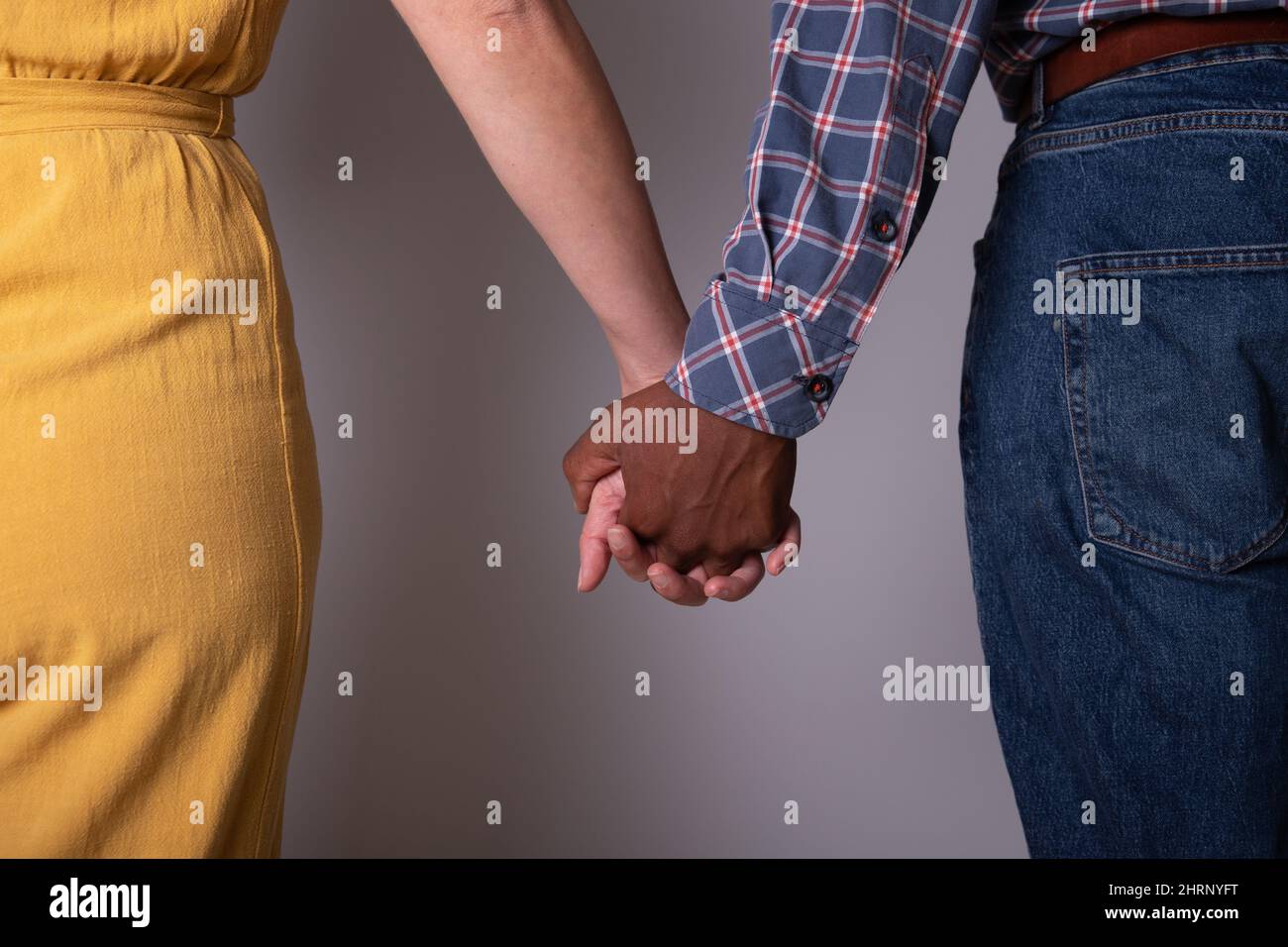 Gros plan des mains d'un couple tenant les mains. Couple interracial, évolution de la société Banque D'Images