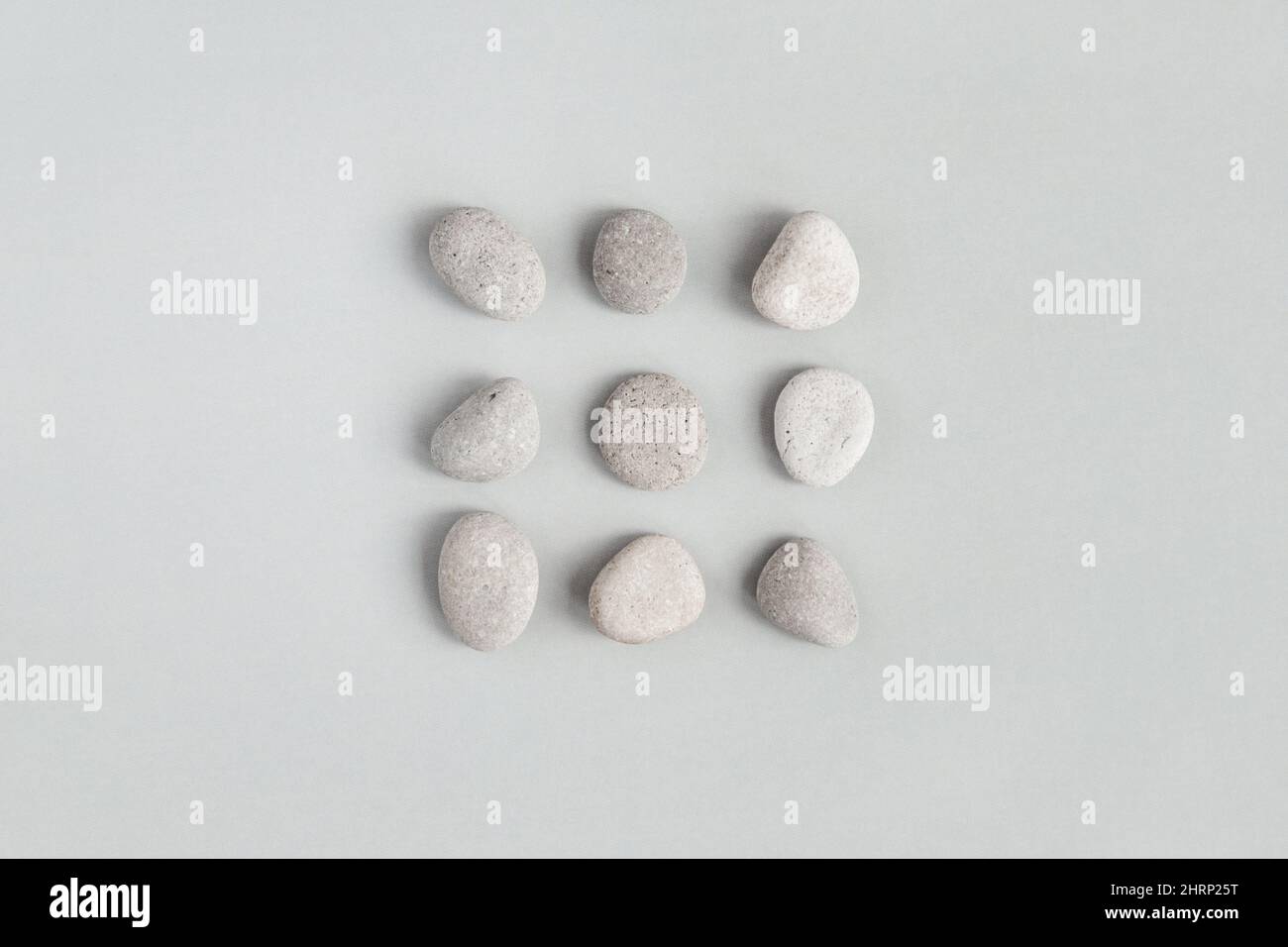 Pierres de galet sur fond gris clair, conception minimaliste plat Banque D'Images