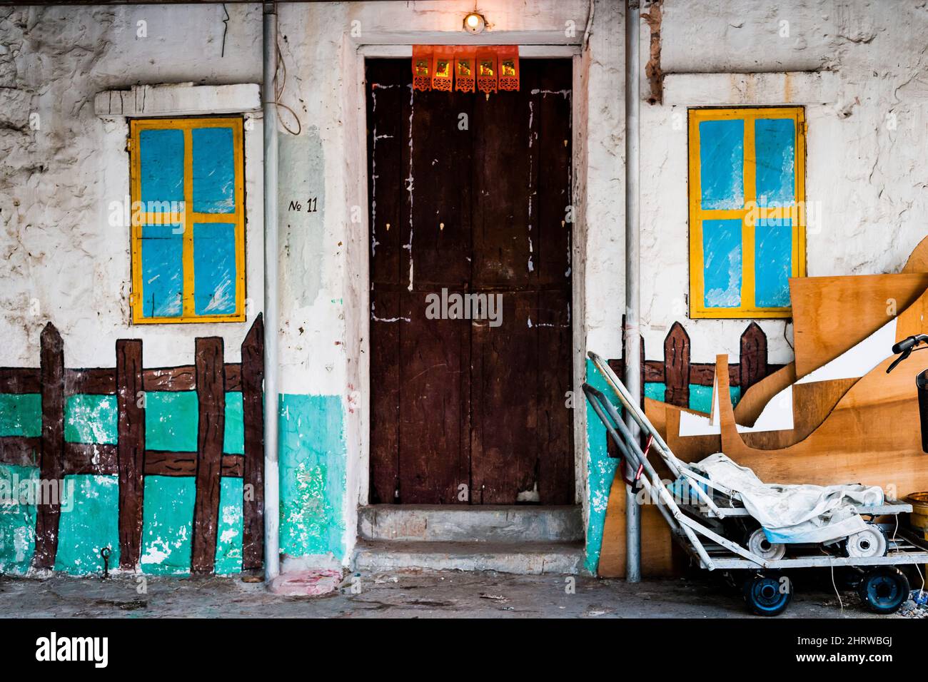 Une vieille maison avec des fenêtres peintes et une clôture de piquetage à Mui WO, sur l'île de Lantau, à Hong Kong Banque D'Images