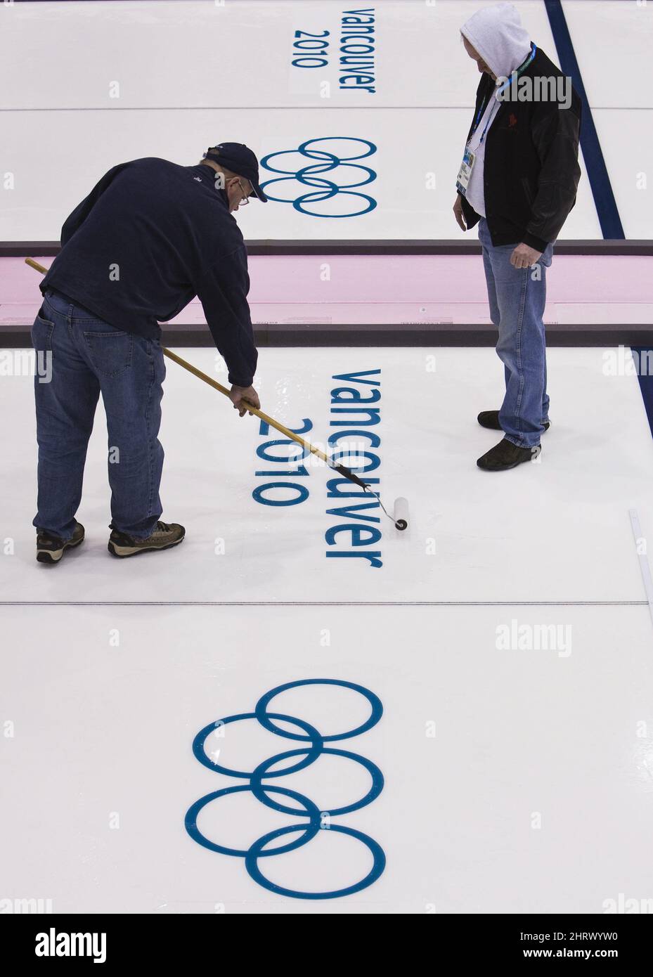 Les travailleurs de la glace roulent sur l'eau au-dessus des emblèmes des Jeux olympiques d'hiver au Centre olympique de Vancouver, où le curling aura lieu le mardi 9 février 2010 aux Jeux olympiques d'hiver de 2010 à Vancouver. (Photo de la PB/la presse canadienne, Nathan Denette) Banque D'Images