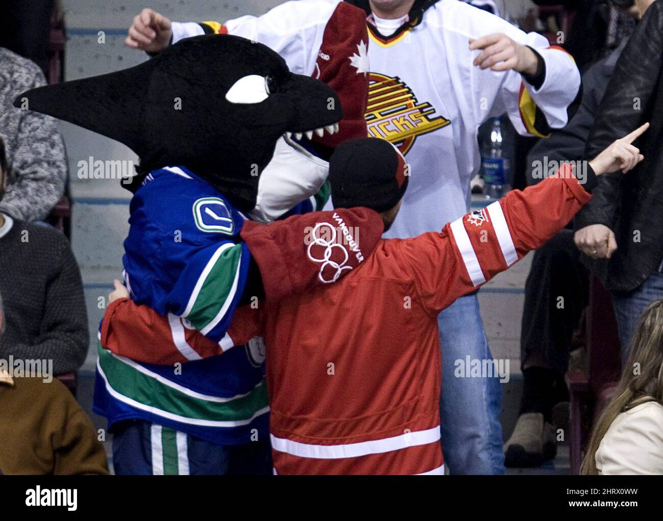Fin, la mascotte Canuck de Vancouver porte une paire de moufles rouges  olympiques alors qu'il s'affronte avec un fan pendant la troisième période  d'un match de la LNH entre les Canucks et