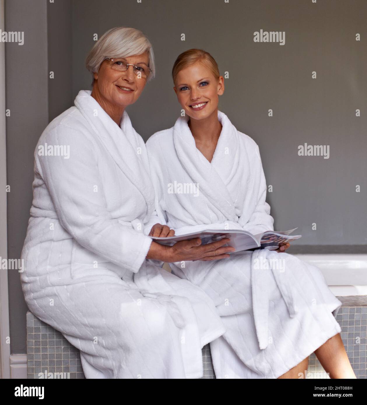 Discuter des épouses du grand jour. Grand-mère et petite-fille qui feuillette un magazine. Banque D'Images