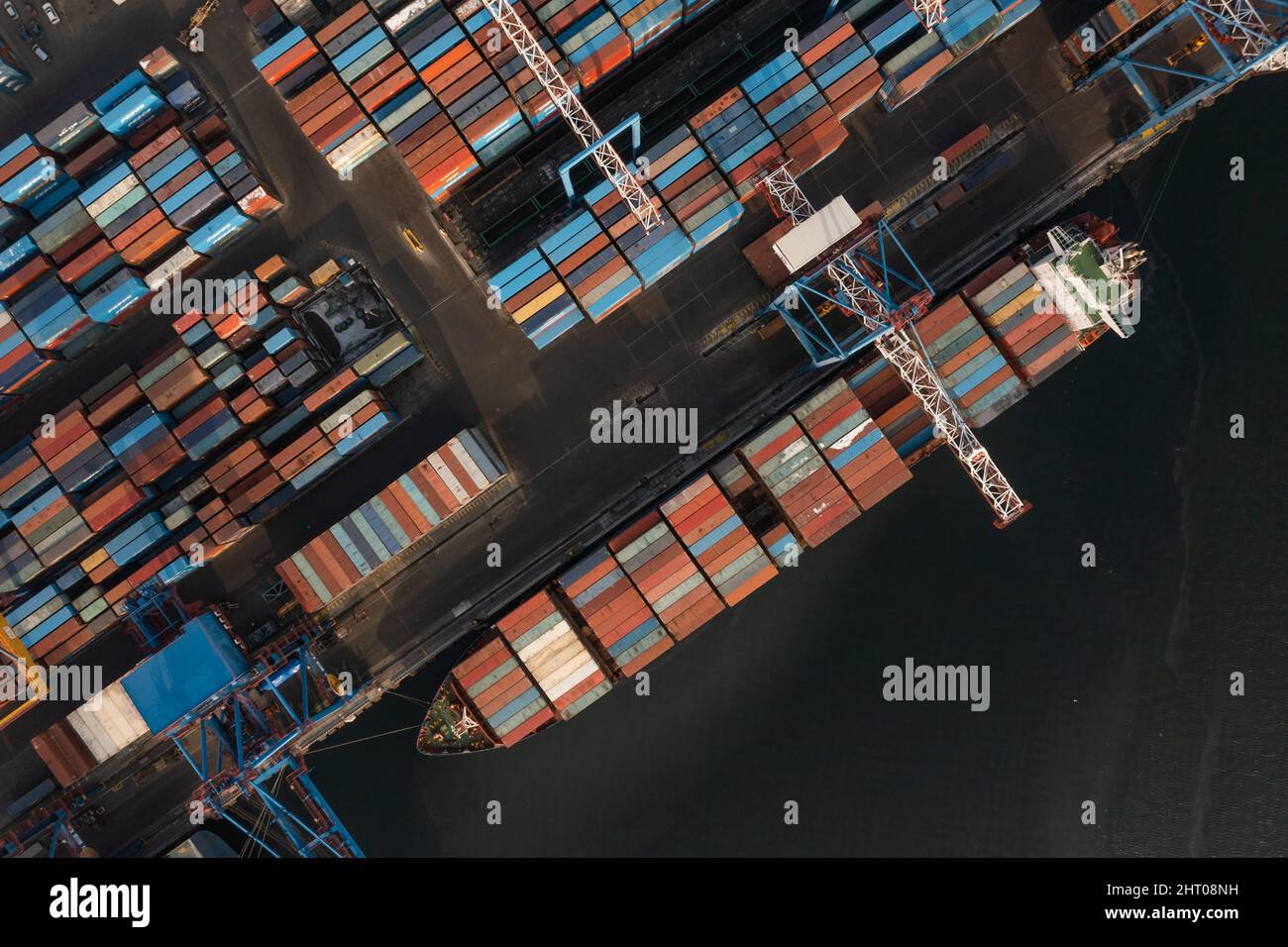 Vladivostok, Russie - 26 janvier 2022 : Vue de dessus du terminal des conteneurs du port maritime.En hiver, un bateau à conteneurs est en train de charger à l'embarcadère. Banque D'Images