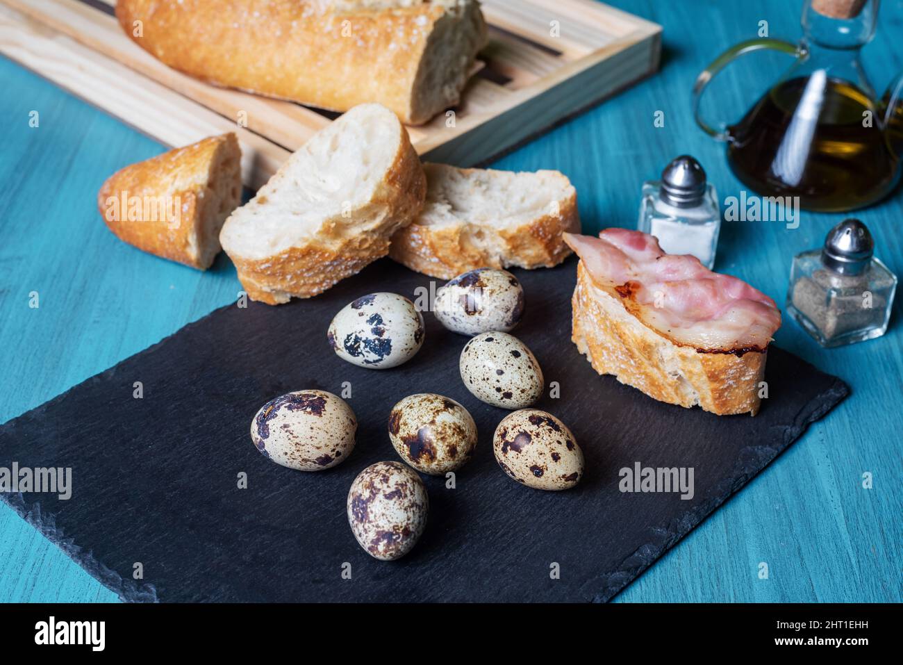 Caille les œufs à côté de quelques tranches de pain et de bacon. Banque D'Images Caille les œufs à côté de quelques tranches de pain et de bacon. Banque D'Images