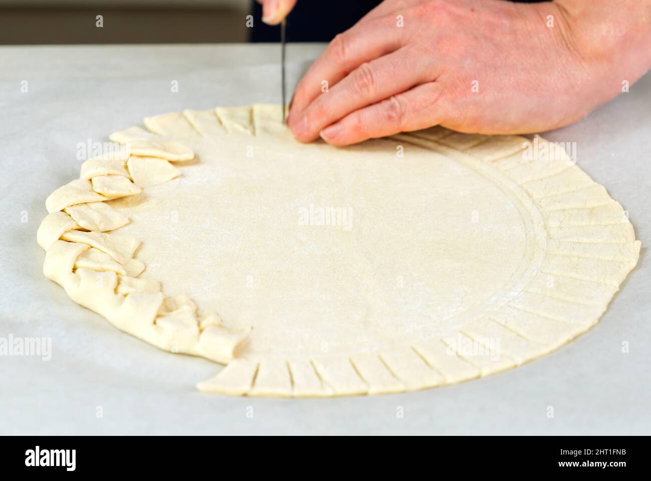 Processus de fabrication de pizza. Vue de dessus de la base de pâte à pizza. Pizza maison avec une croûte à tarte tressée. Banque D'Images