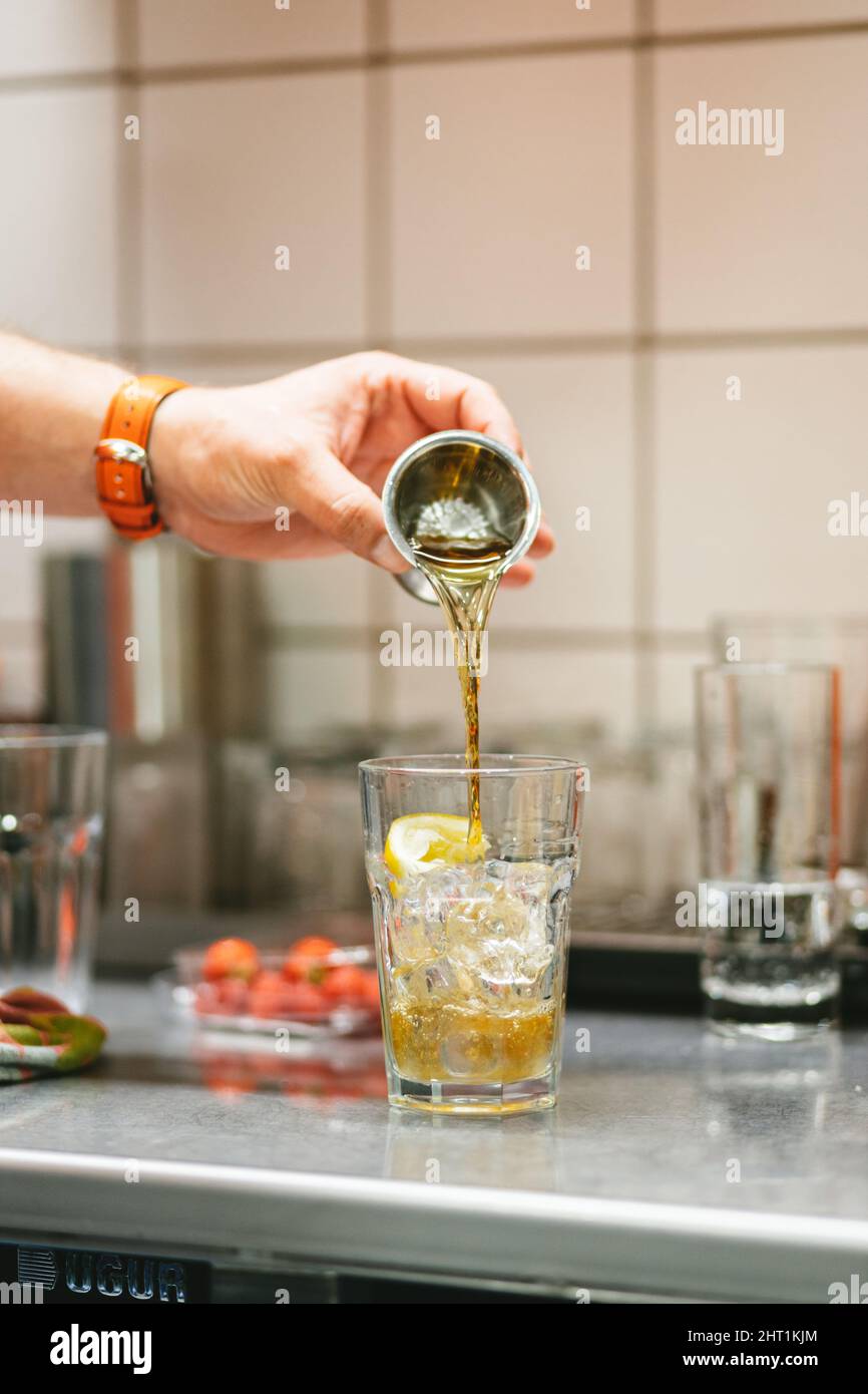 Un gros plan vertical de la main préparant une boisson de Margarita classique à base d'alcool de Cointreau. Banque D'Images