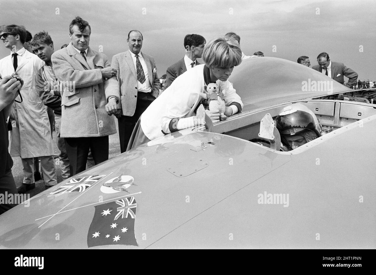 Proteus Bluebird, la voiture dans laquelle Donald Campbell a battu le record mondial de vitesse automobile a maintenant fait sa dernière course, à 5 km/h, à la station RAF, Debden, Essex, 19th juin 1966. Campbell devait faire une démonstration lors d'un gala, Mais 5 jours plus tôt, la voiture a été gravement endommagée quand, avec le pilote de course Peter Bolton aux commandes, elle a heurté une clôture en bois et une haie à 100 km/h, a navigué 10ft dans les airs en traversant la route de Cambridge Chelsford et a finalement tourné sur un terrain de 200 mètres. Également en photo, la femme Tonia Campbell. Banque D'Images