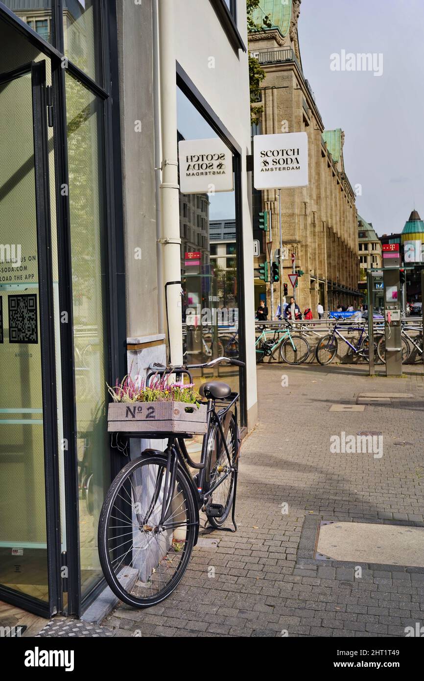 Vélo avec fleurs devant un magasin Scotch & Soda dans la vieille ville de Düsseldorf/Allemagne. La vieille ville est une zone touristique populaire avec de nombreux magasins. Banque D'Images