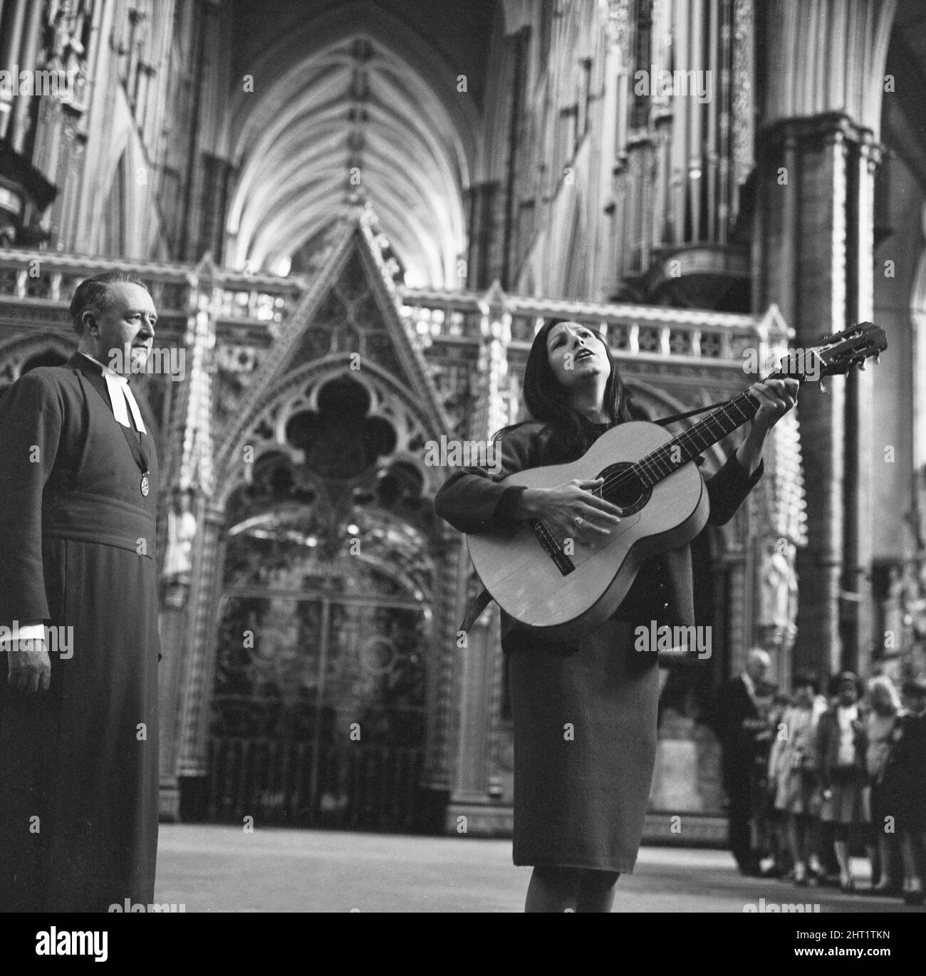 Mlle Julie Felix qui a fait beaucoup de travail volontaire pour Christian Aid, est de chanter à un Service spécial pour les jeunes qui se tiendra à l'abbaye de Westminster le samedi 4th 1966 juin.Julie est vu ici répéter pendant que le doyen de Westminster (Eric S Abbott) regarde. 18th mai 1966 W4932 Banque D'Images