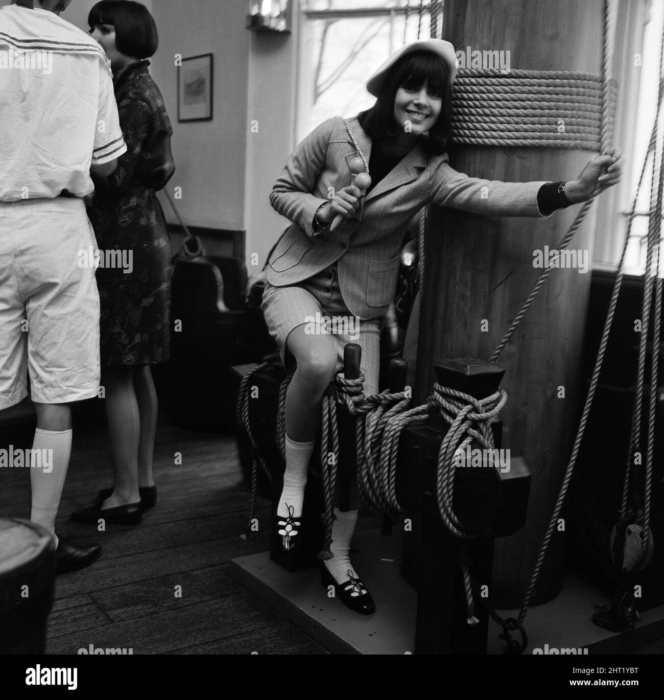 Chantal Goya, jeune pop-star française (assis près du mât), photographiée au salon des designers de vêtements français Bagatel à la Trafalgar Tavern de Greenwich, Londres. Photo prise le 18th novembre 1965. Chantal porte un costume de culotte en flanelle anglais vert à rayures sauge. Banque D'Images