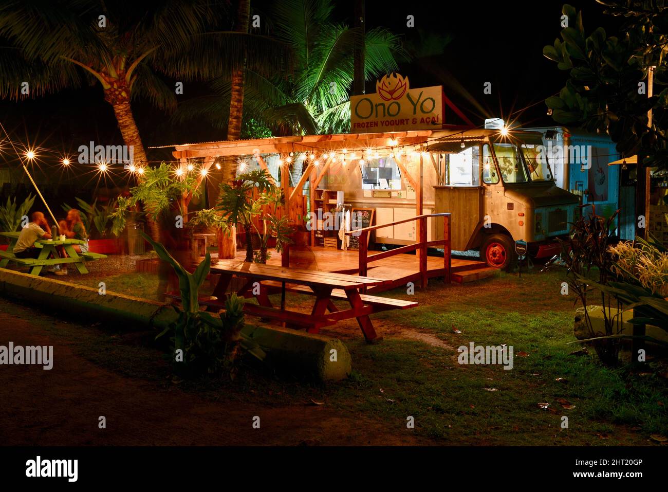 Camion alimentaire, feux de strung et tables de pique-nique, la nuit, vendant des yaourts glacés tropicaux, des bols d'acai brésiliens, sur la rive nord, Oahu, Kahuku, Hawaï, États-Unis Banque D'Images