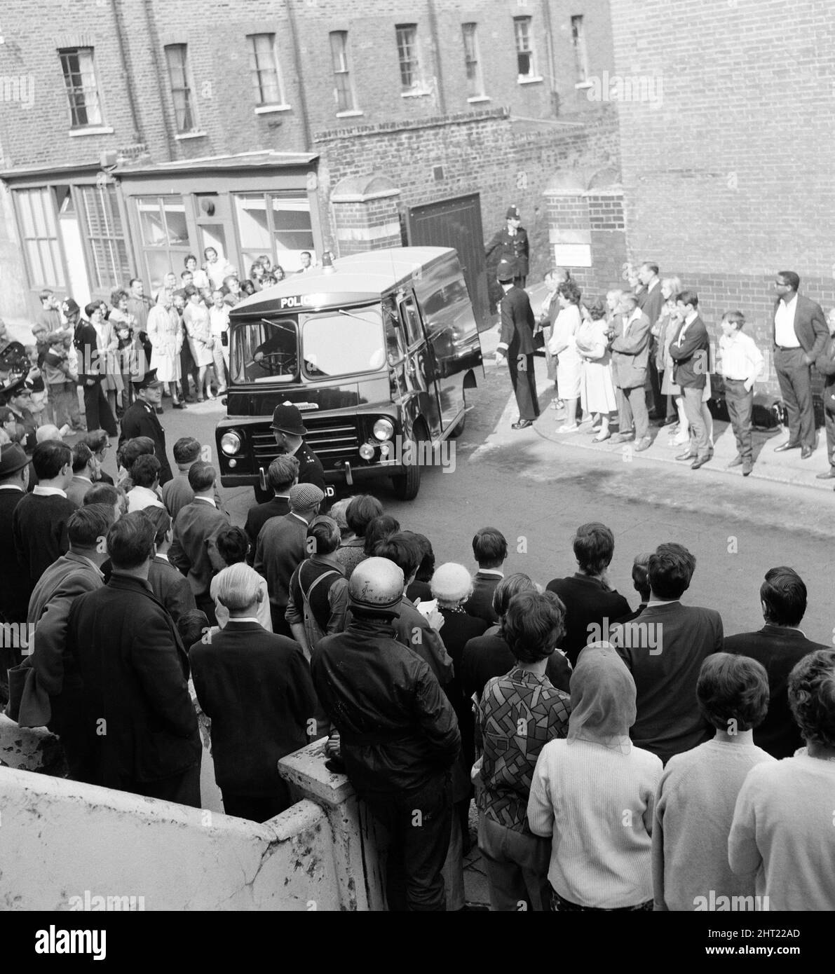 John Edward Witney, 36 ans, qui a été accusé du meurtre de 3 policiers, a été emmené du poste de police de Shepherds Bush (le QG du meurtre) et conduit au tribunal de la magistrature de West London, où il a fait une brève comparution et a été remis en détention jusqu'en août 23. La fourgonnette de police contenant Witney quitte West London court. 16th août 1966. Banque D'Images