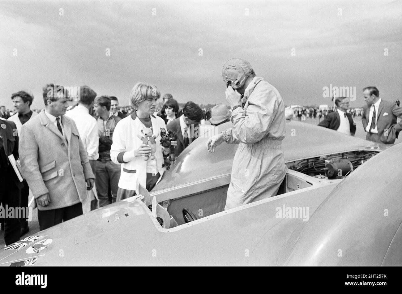 Proteus Bluebird, la voiture dans laquelle Donald Campbell a battu le record mondial de vitesse automobile a maintenant fait sa dernière course, à 5 km/h, à la station RAF, Debden, Essex, 19th juin 1966. Campbell devait faire une démonstration lors d'un gala, Mais 5 jours plus tôt, la voiture a été gravement endommagée quand, avec le pilote de course Peter Bolton aux commandes, elle a heurté une clôture en bois et une haie à 100 km/h, a navigué 10ft dans les airs en traversant la route de Cambridge Chelsford et a finalement tourné sur un terrain de 200 mètres. Également photographié, Tonia Campbell avec des jouets en peluche. Banque D'Images